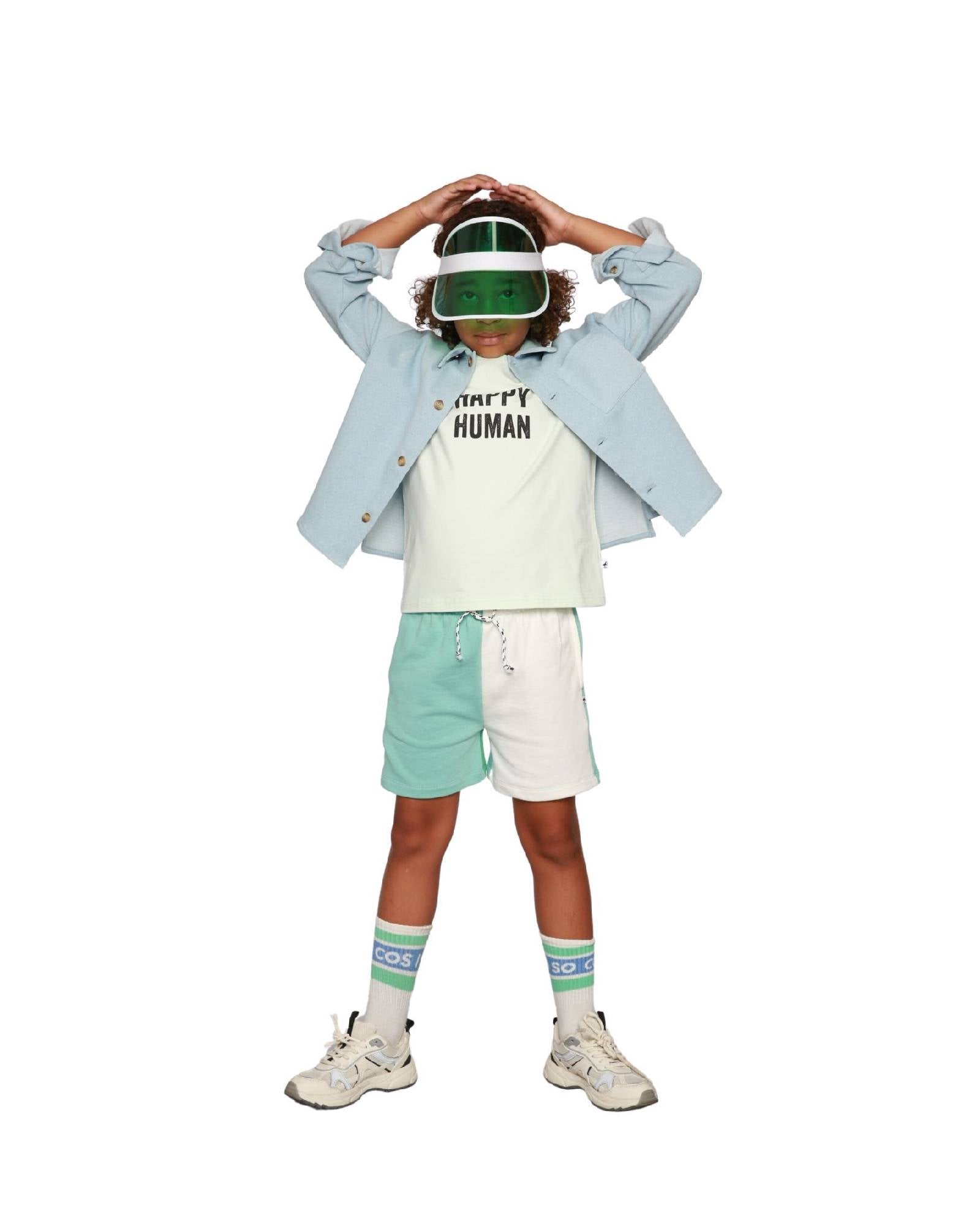 Boy model wearing T-shirt Happy Human in Aqua Glass and the Jog Shorts in Color Block with the Logo socks in White.
