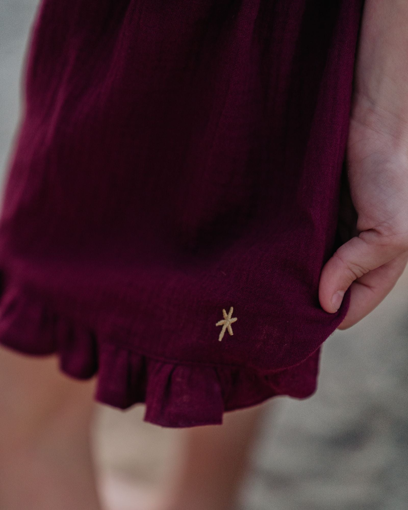 Girl model wearing the Charlene Shorts in Aubergine Muslin Cotton, which is a deep purple-reddish hue.
