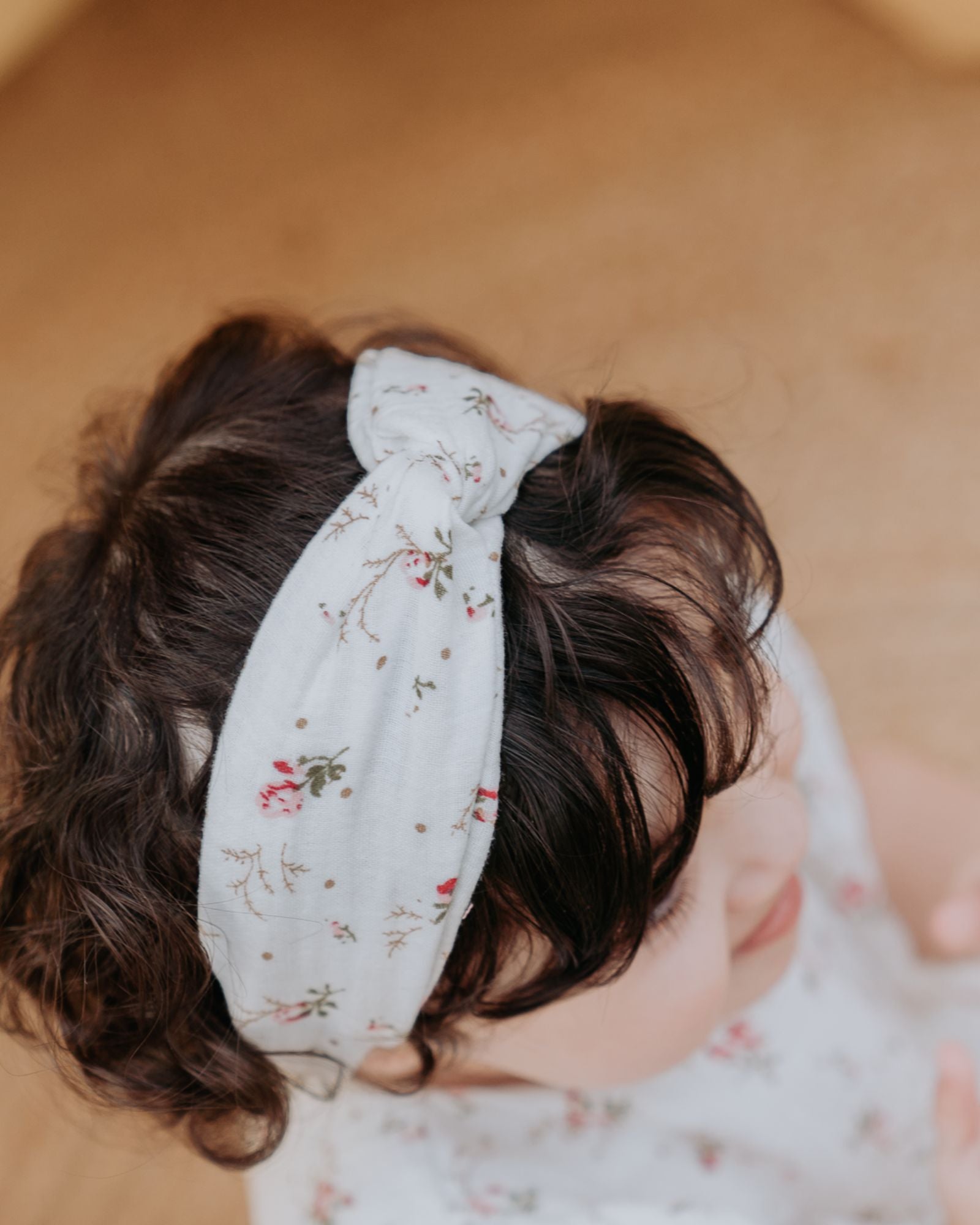 Girls Twisted Headband by Les Vedettes in muslin cotton and shown in the color Wildflower.