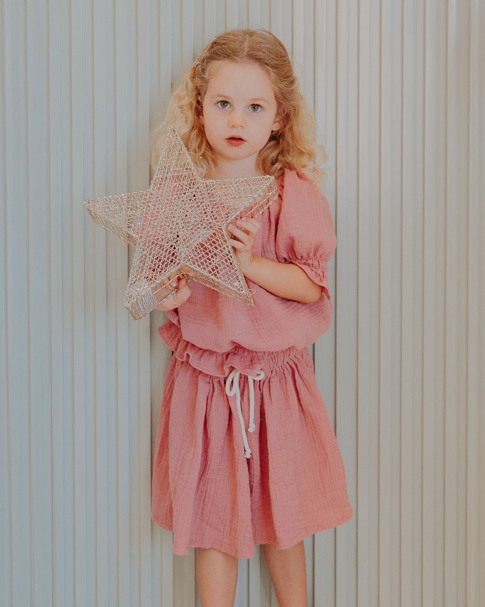 Girl model wearing an outfit by Les Vedettes in Muslin Cotton: Alexa Top in Blush Pink with the matching Sienna Skirt in the color Blush Pink.
