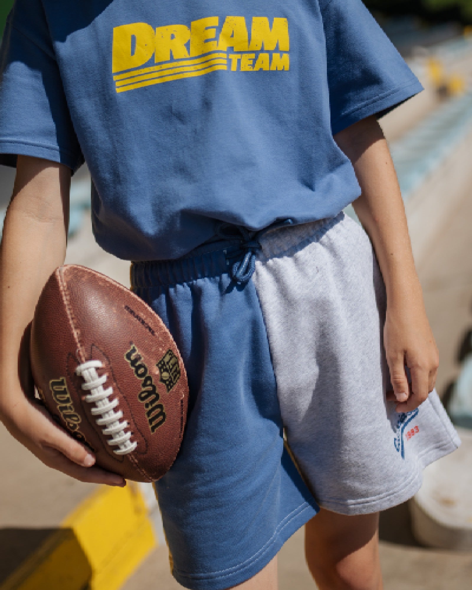 boy model wearing the ciss 1983 colour block jog shorts with the dream team t-shirt in organic cotton