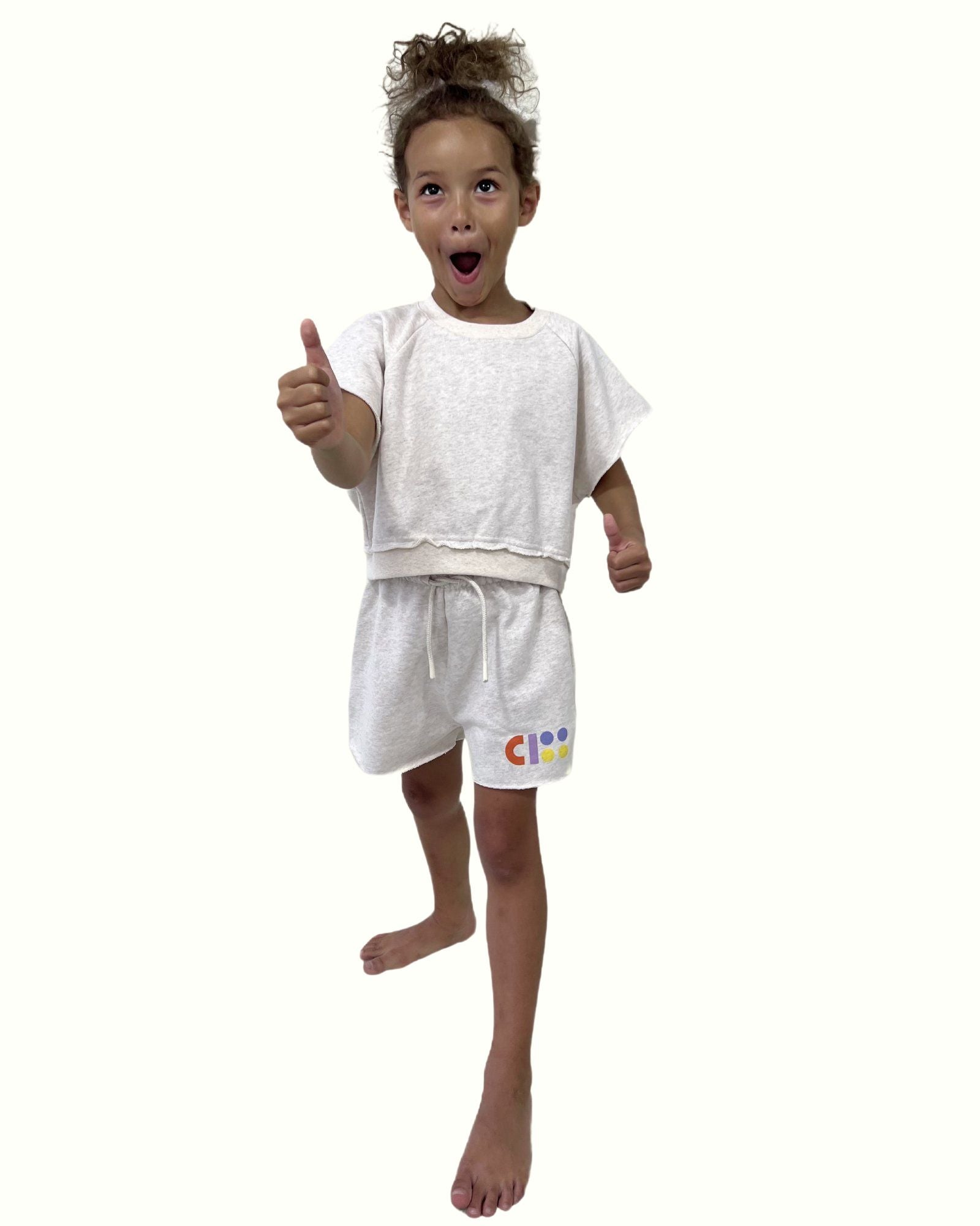 girl model wearing the jog top ciss in light organic cotton sweater fabric by Cos I Said So with the jog shorts ciss, both come in the color off white melange