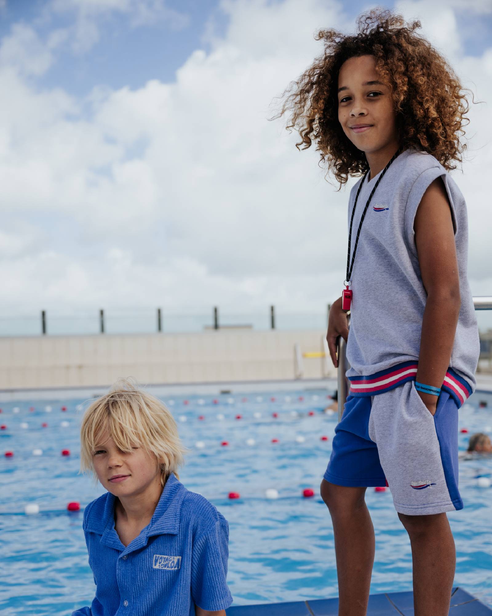boy model wearing the color block jog shorts with the debardeur in grey