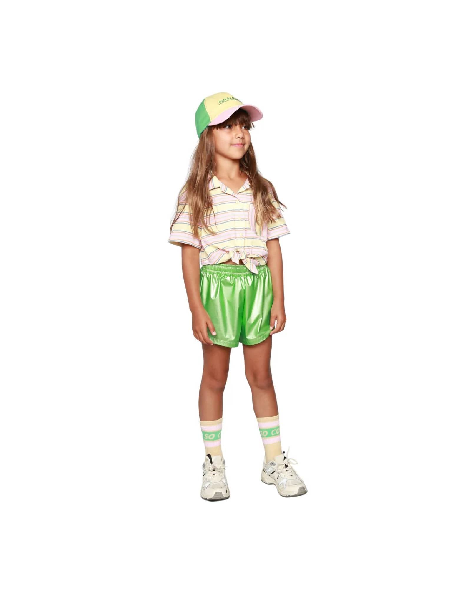 girl model wearing the vegan shorts in lime green with ciss socks in anise and the après sport cap