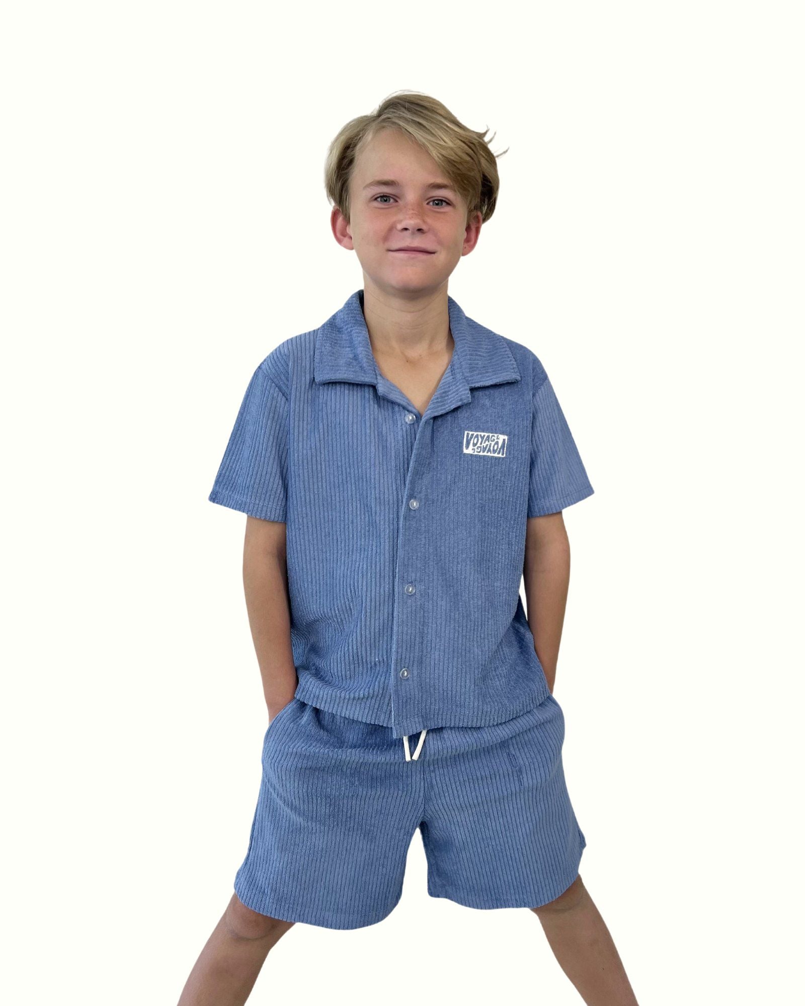 boy model wearing the towel terry shirt by Cos I Said So in blue with the matching towel terry shorts by Cos I Said So