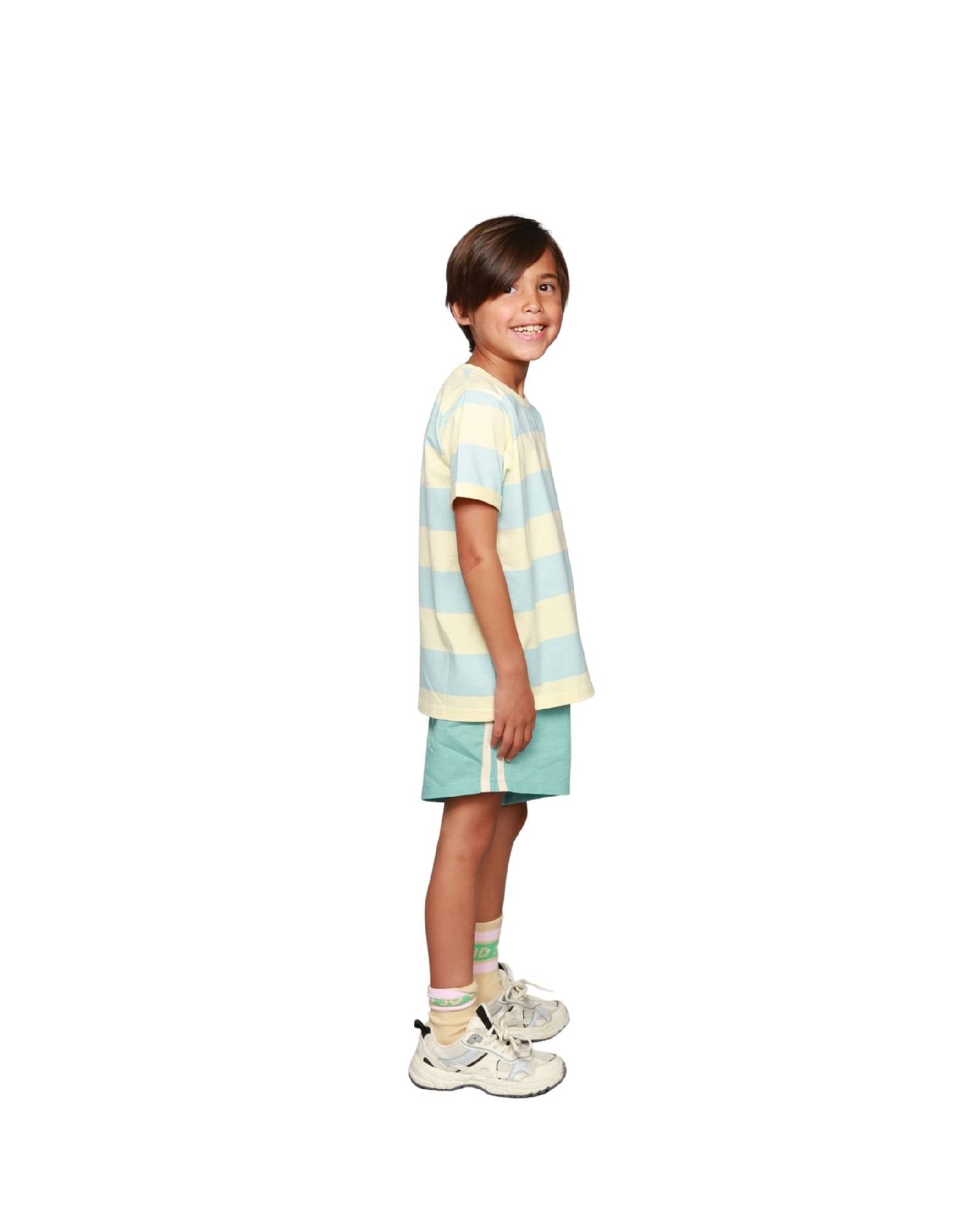 boy model wearing the linen shorts in turquoise with the striped t-shirt aqua haze anise and the socks cos i said so in anise yellow