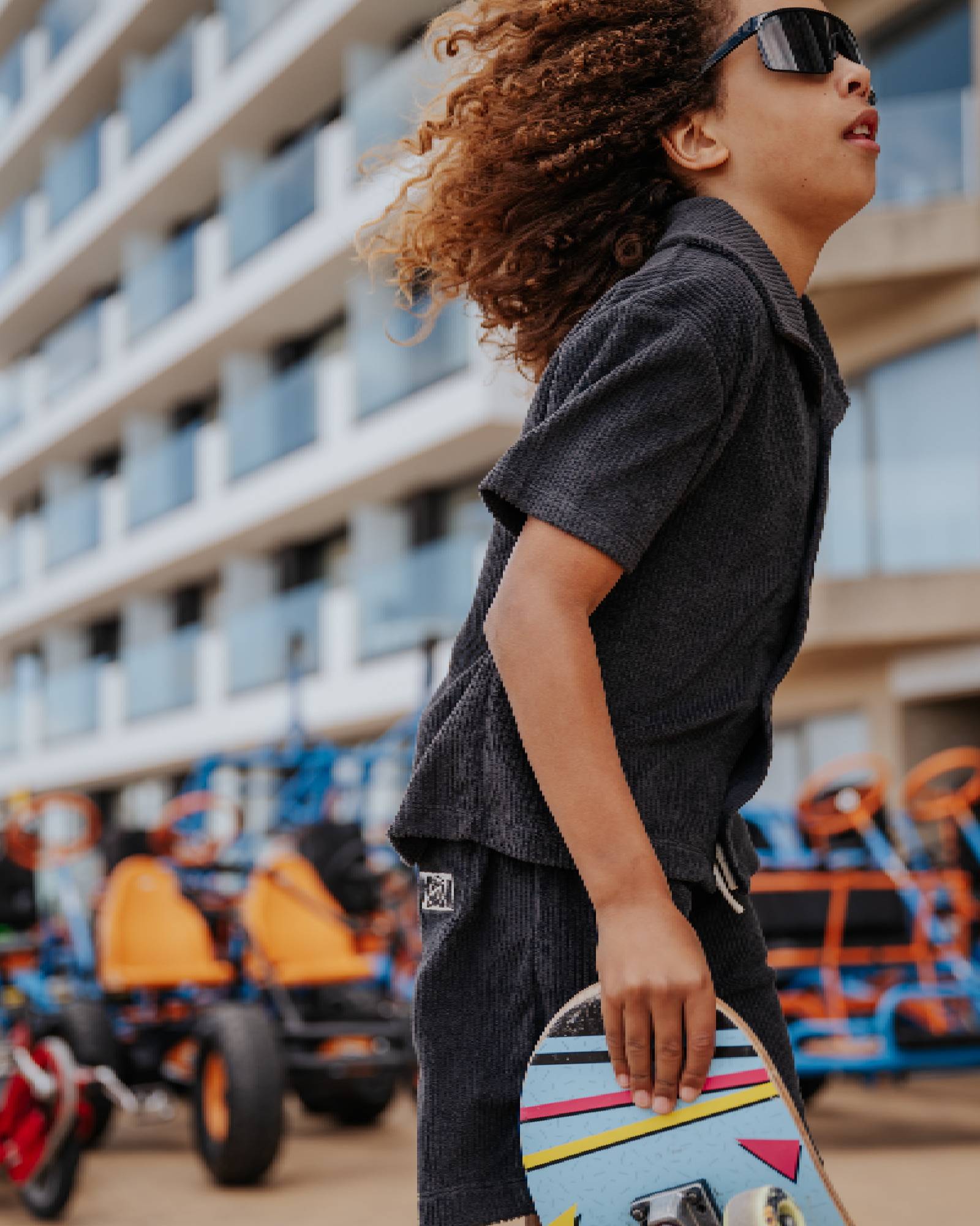 boy model wearing the towel terry shirt in the color charcoal together with the towel terry shorts in charcoal