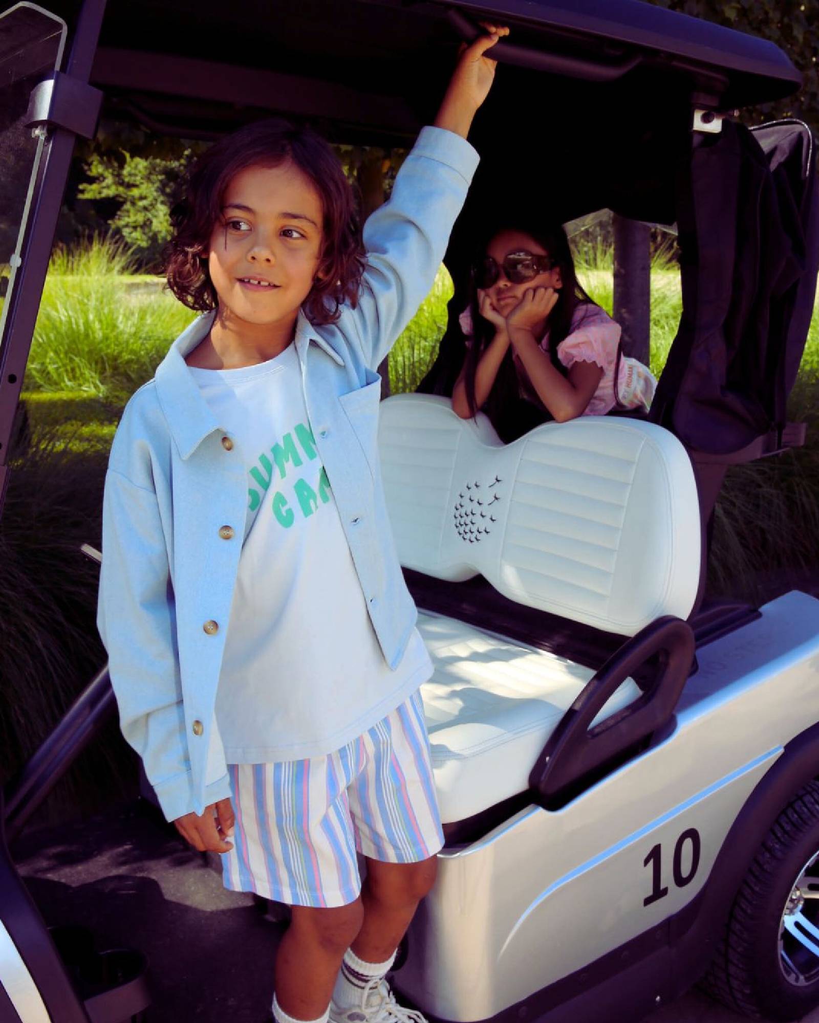 boy model wearing the summer camp t-shirt in arctic ice combined with the swim shorts striped