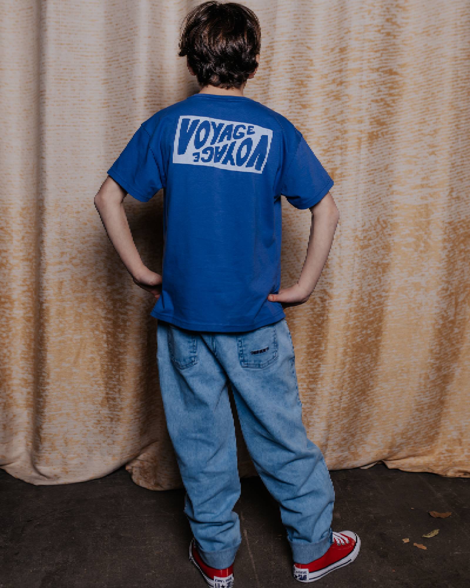 boy model wearing the voyage t-shirt in ultramarine blue in high quality organic cotton, showing the backside