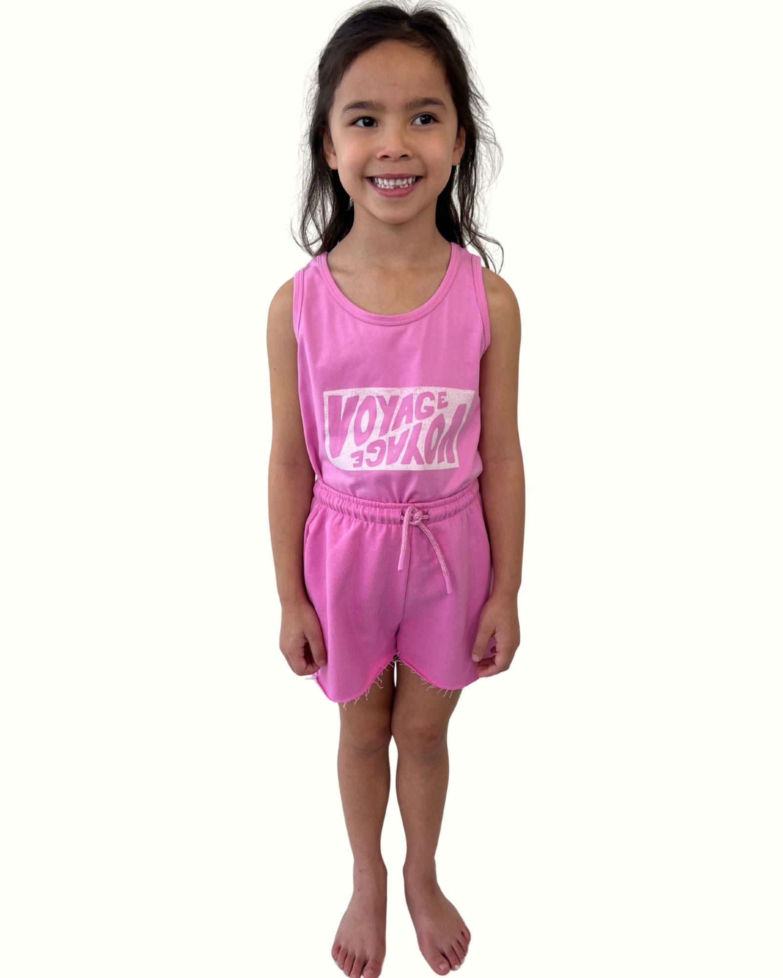 girl model wearing the comy cut off shorts by Cos I Said So in the vibrant color fuchsia with matching tank top voyage voyage in fuchsia high quality organic cotton