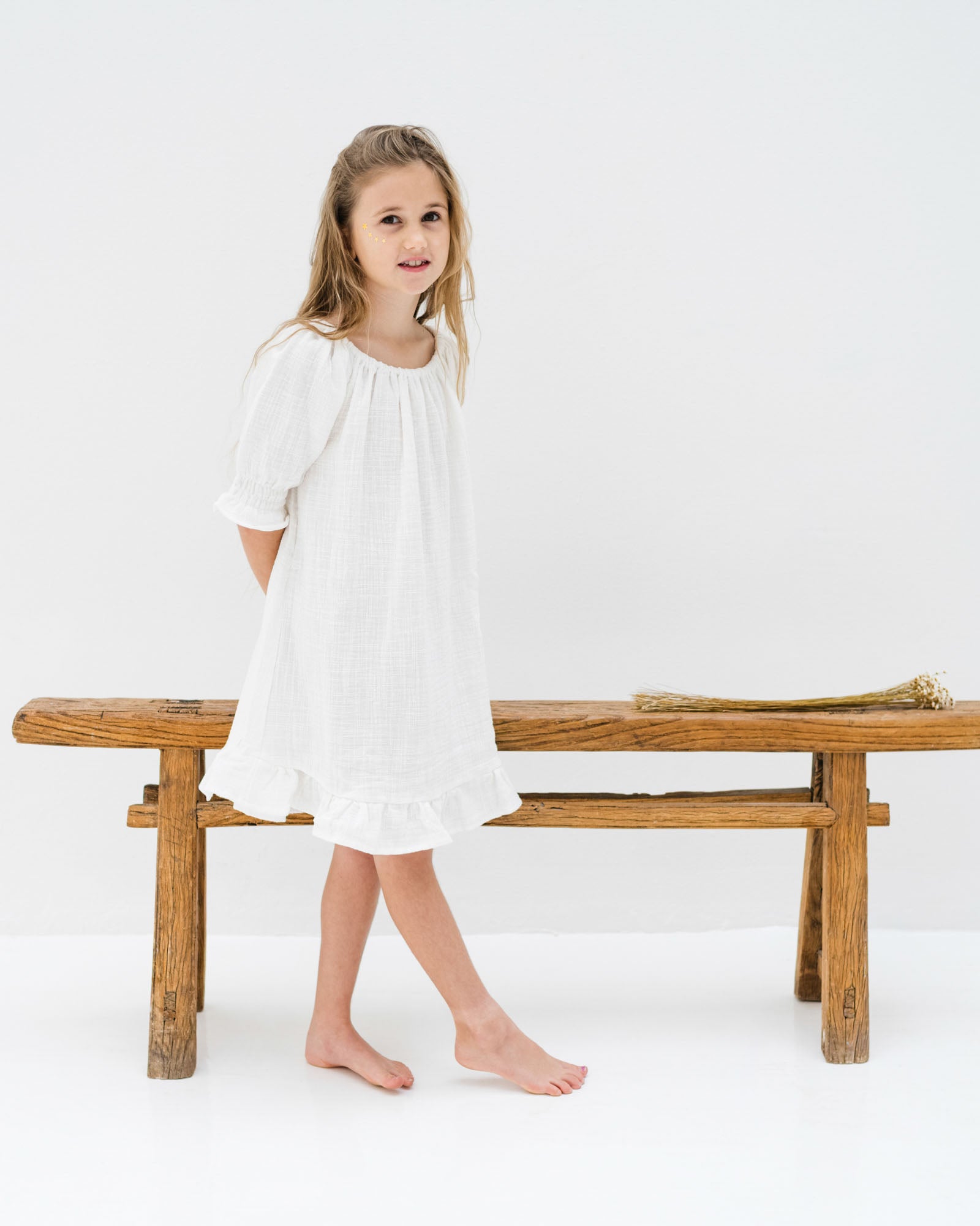 girl model wearing the Alexa dress in the beaytiful fabric white linen