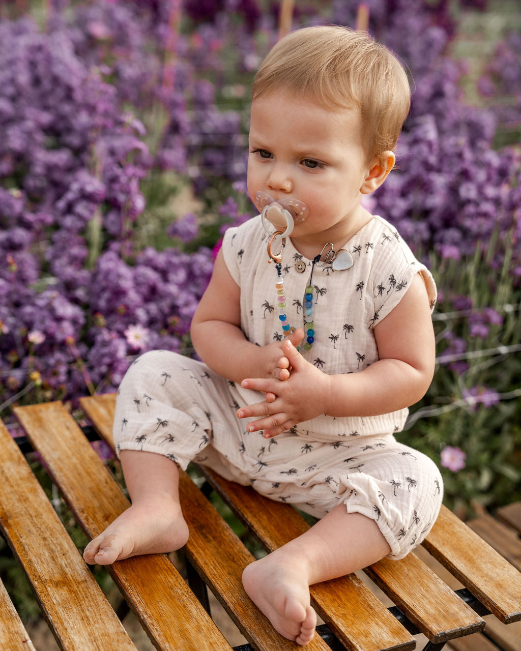 baby boy wearing the the Lois baby onesie in palms muslin cotton