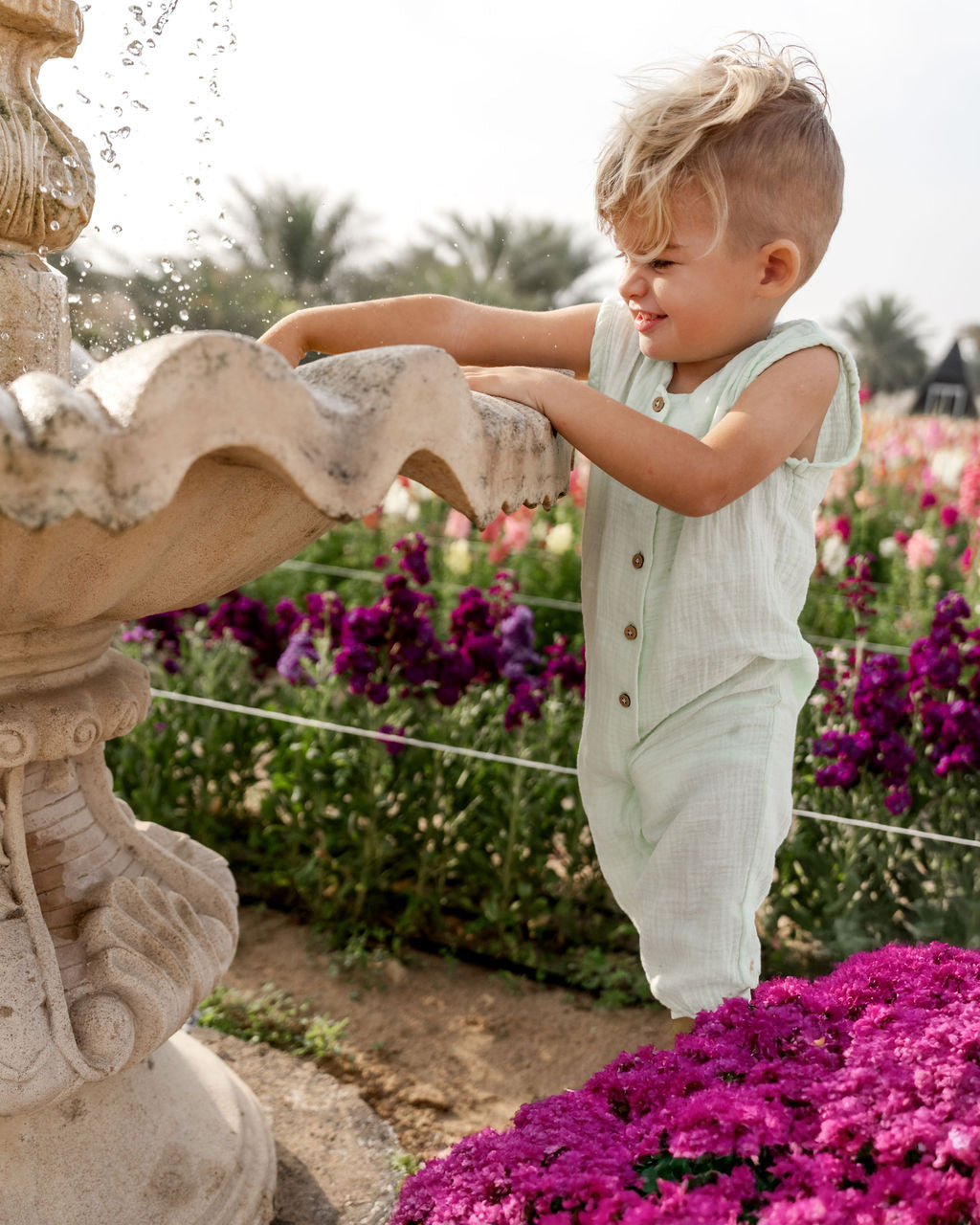 little boy wearing the Lois onesie in mint green muslin cotton