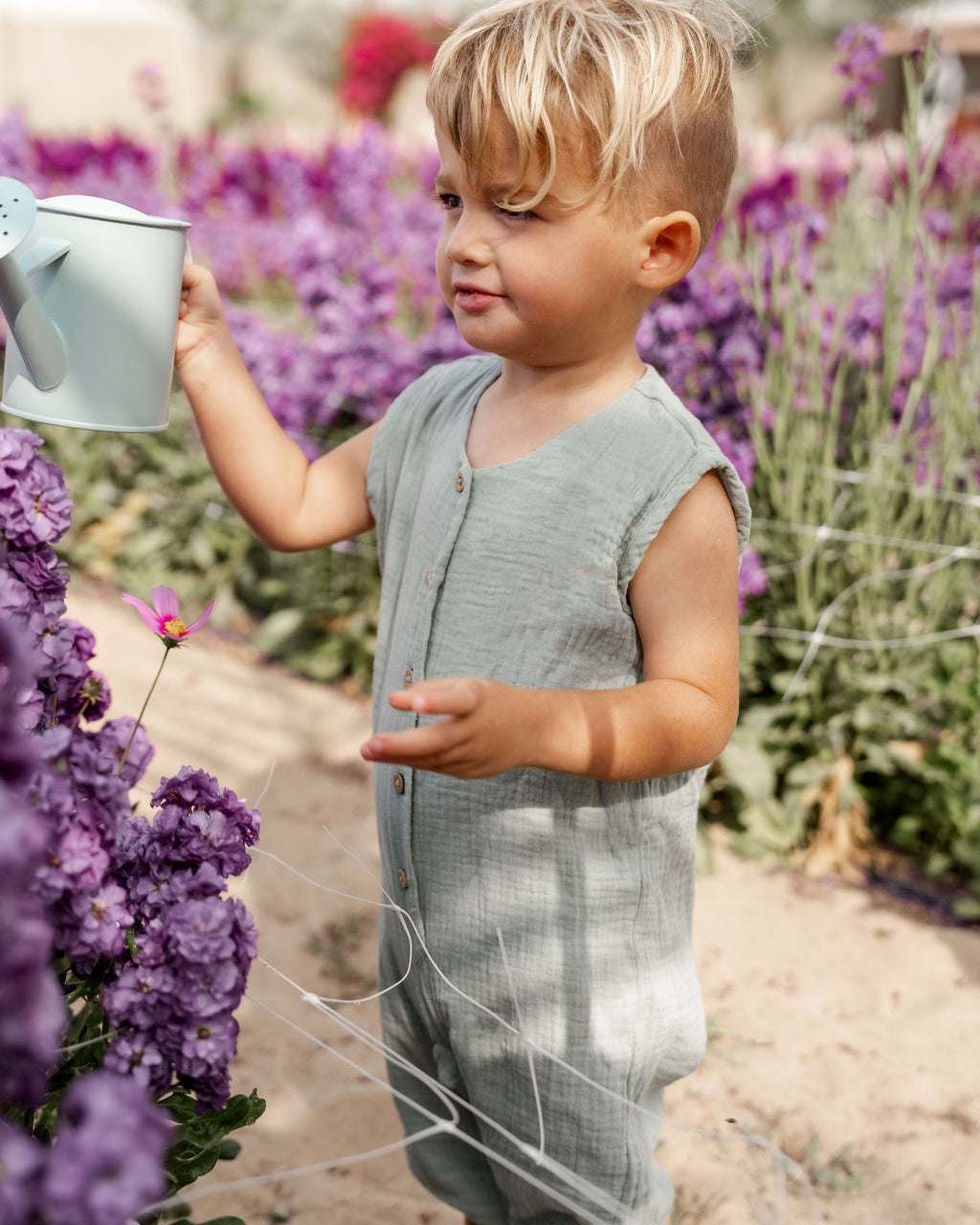 little boy wearing the Lois romper in sage green muslin cotton