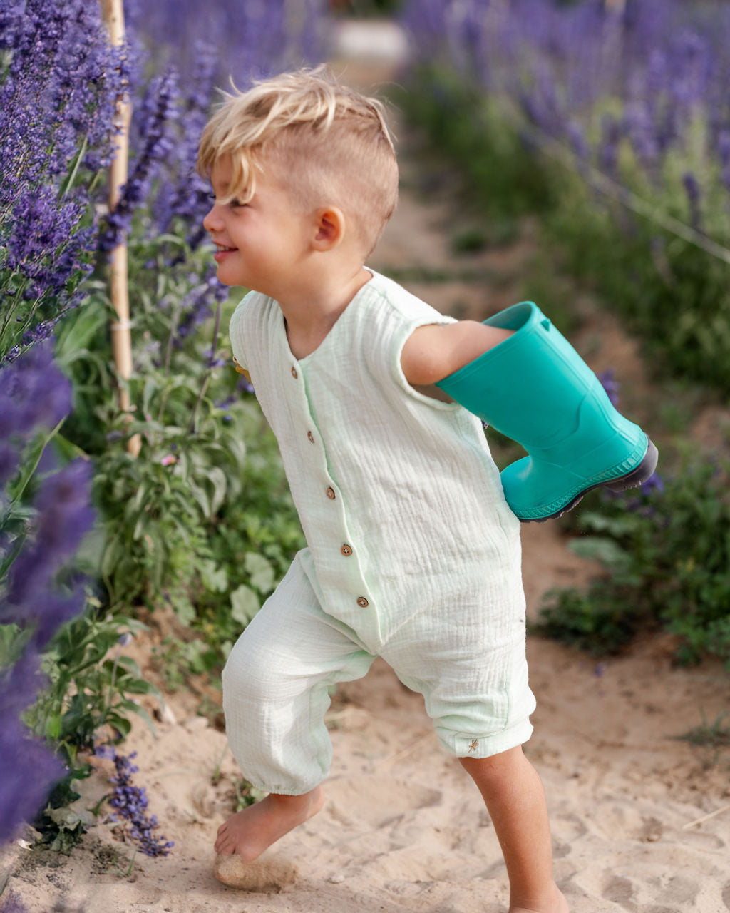 toddler boy wearing the Lois romper in mint green muslin cotton