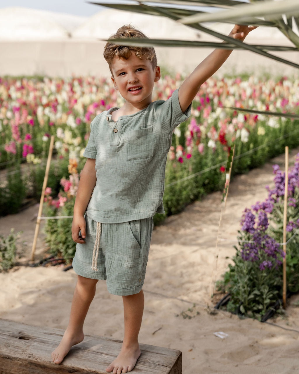 boy model wearing the Charlie top in sage green combined with the Julian shorts in sage green