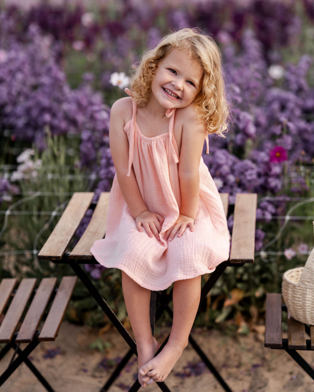 girl model wearing the Romy dress in peach muslin cotton