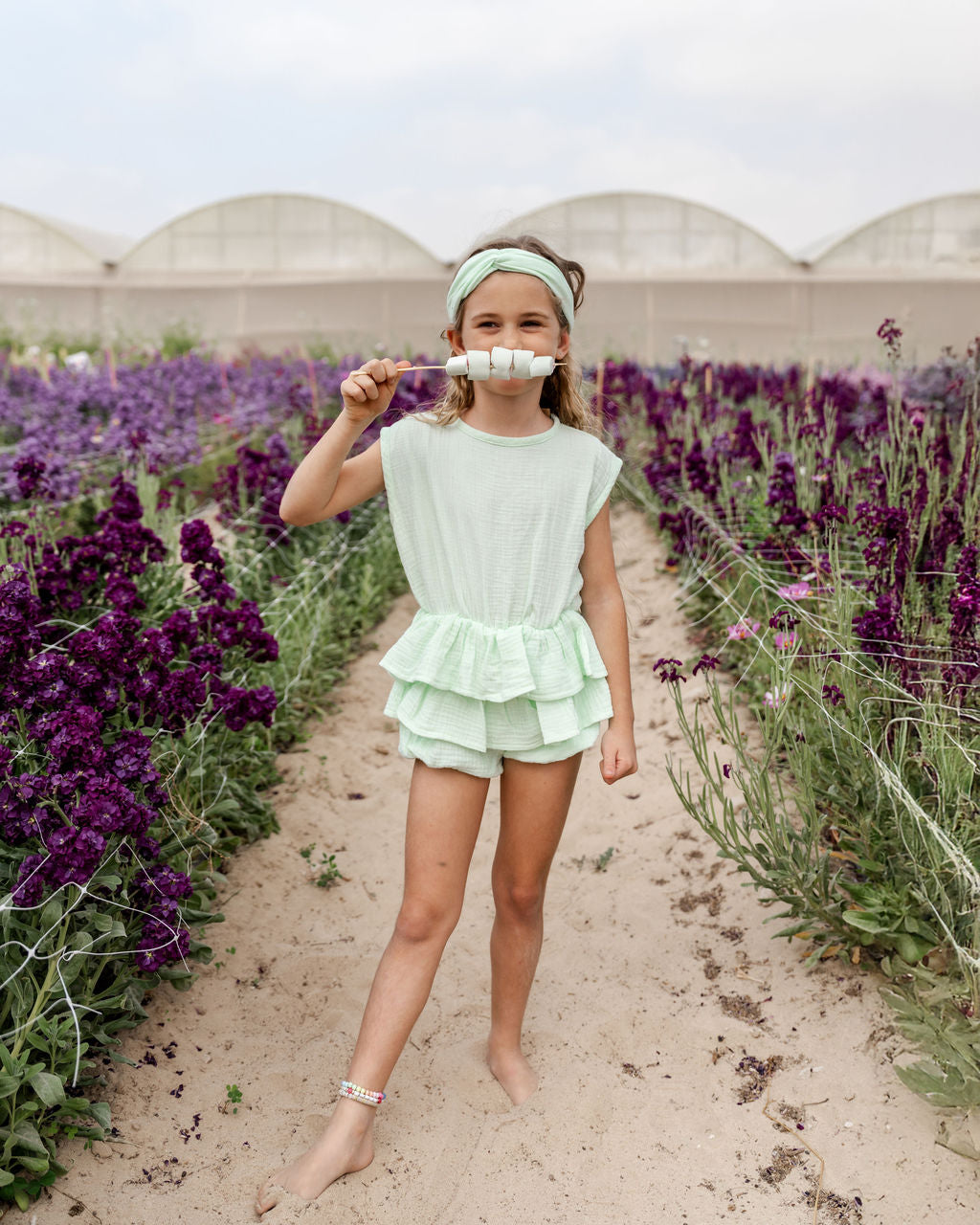 girl model wearing the stunning onesie in the vibrant color mint in high quality muslin cotton with matching twisted headband in mint