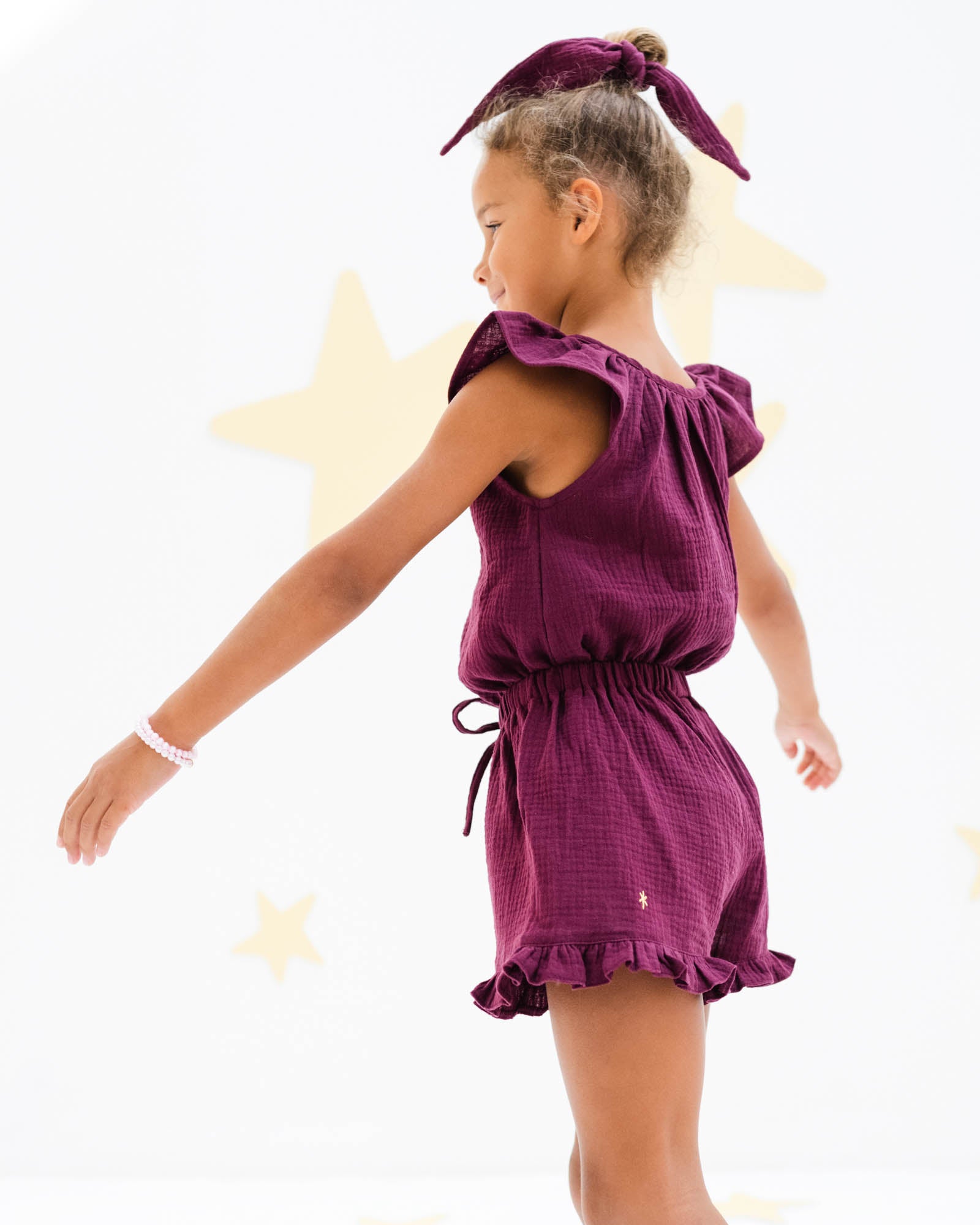 7-year-old girl wearing the Lilou top and matching Charlene shorts in a high quality aubergine muslin