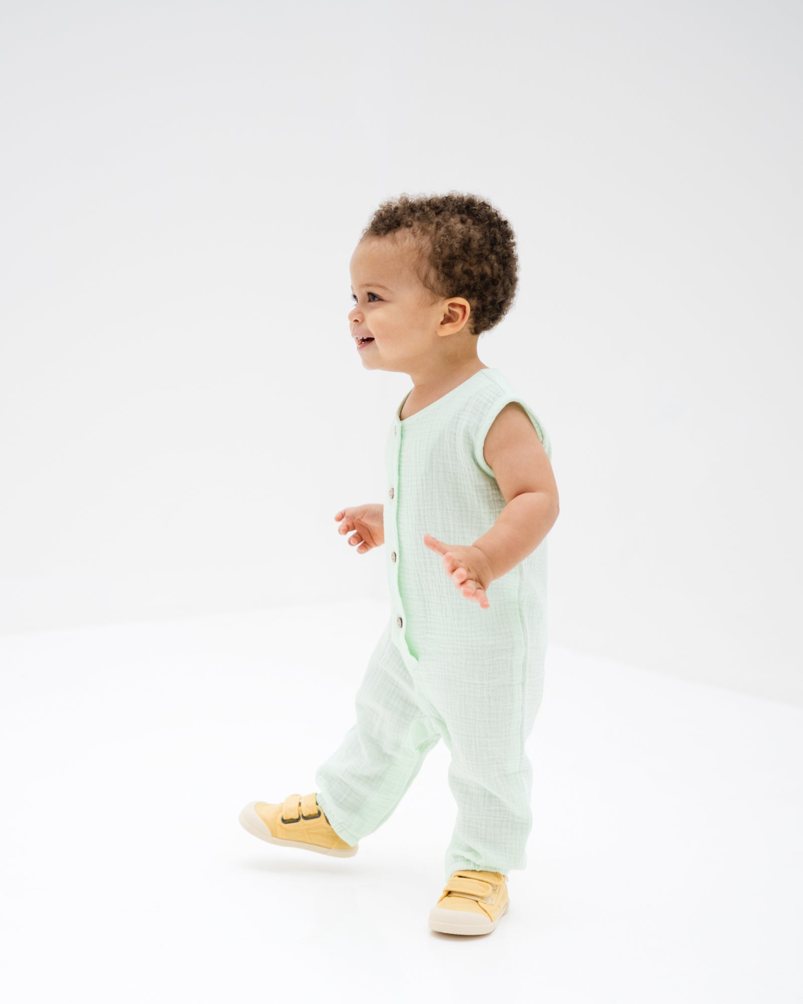 baby boy showing the sleeveless lois onesie in mint green