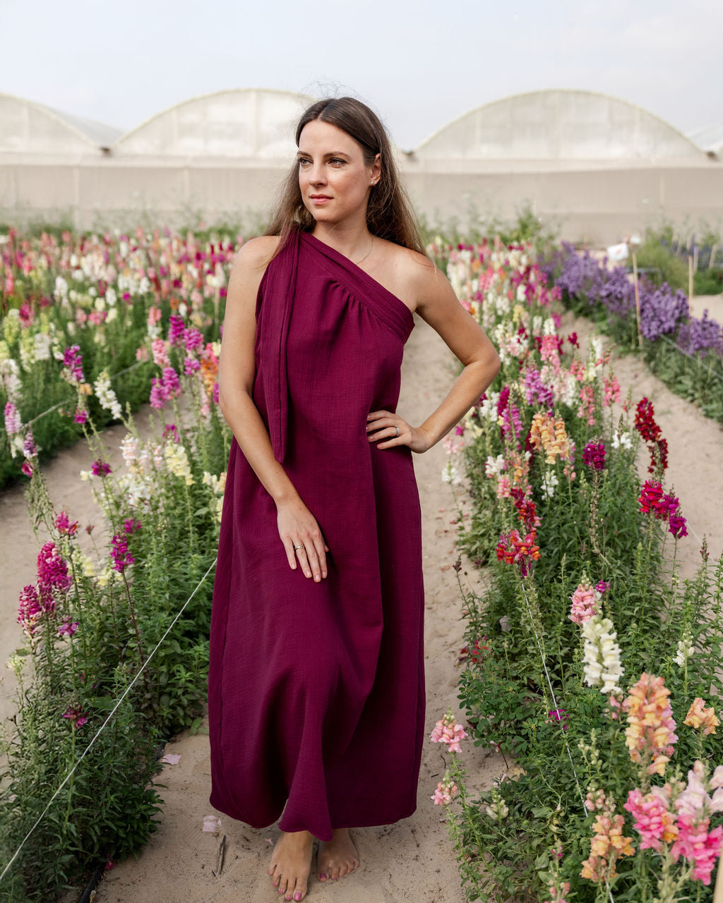 model wearing the assymetric Olympia dress in aubergine muslin cotton