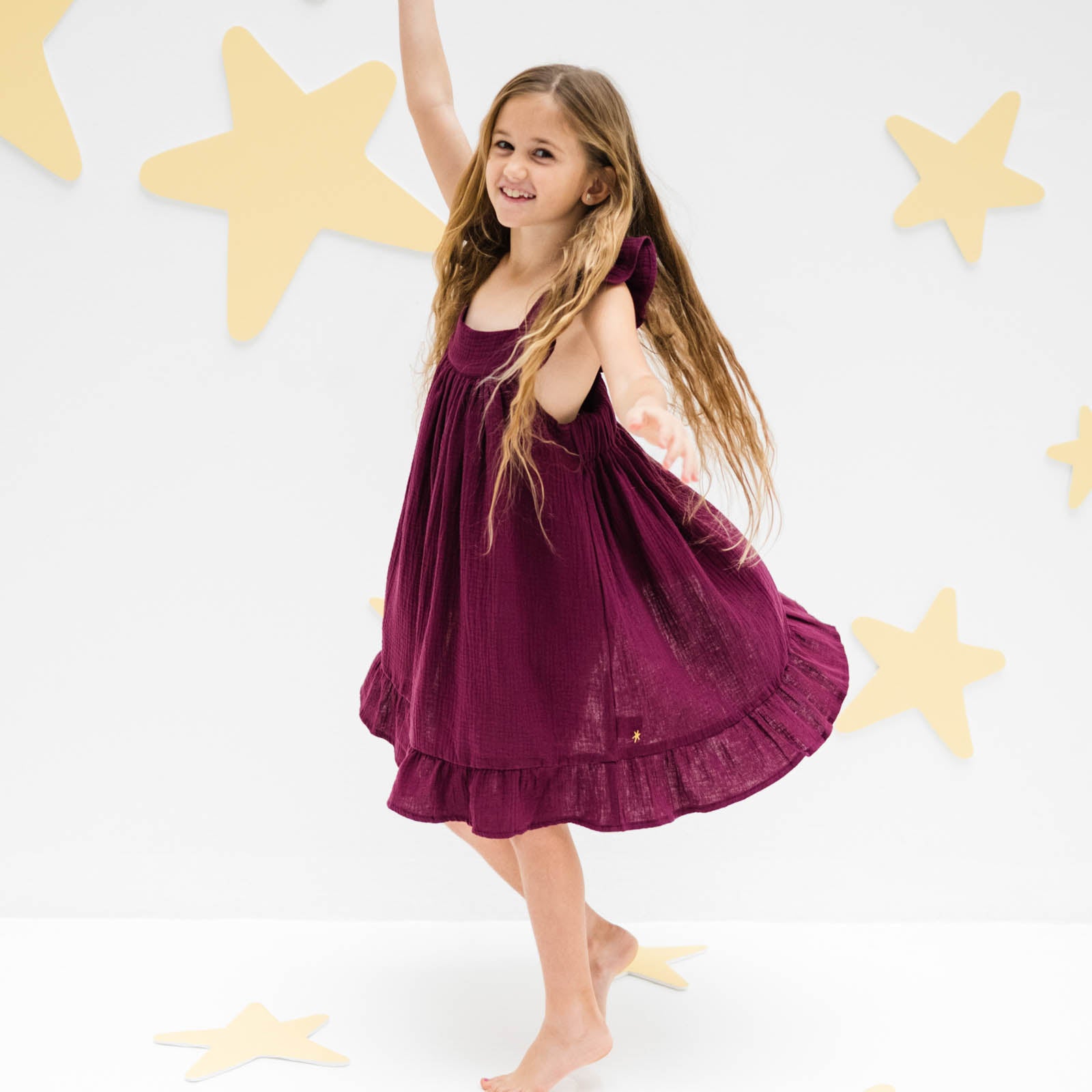 girl model showing the left side of the river dress in aubergine muslin cotton