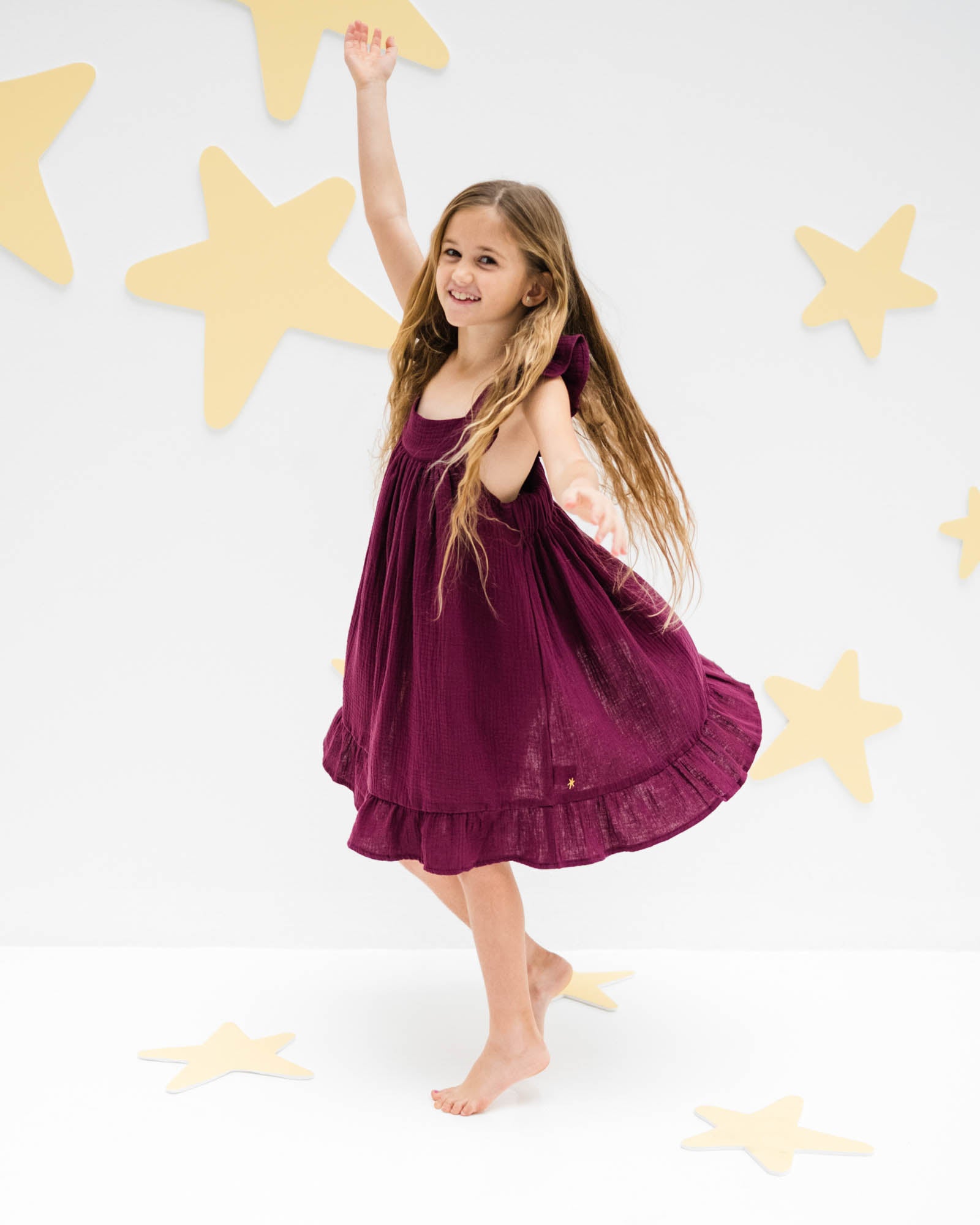 girl model showing the left side of the river dress in aubergine muslin cotton