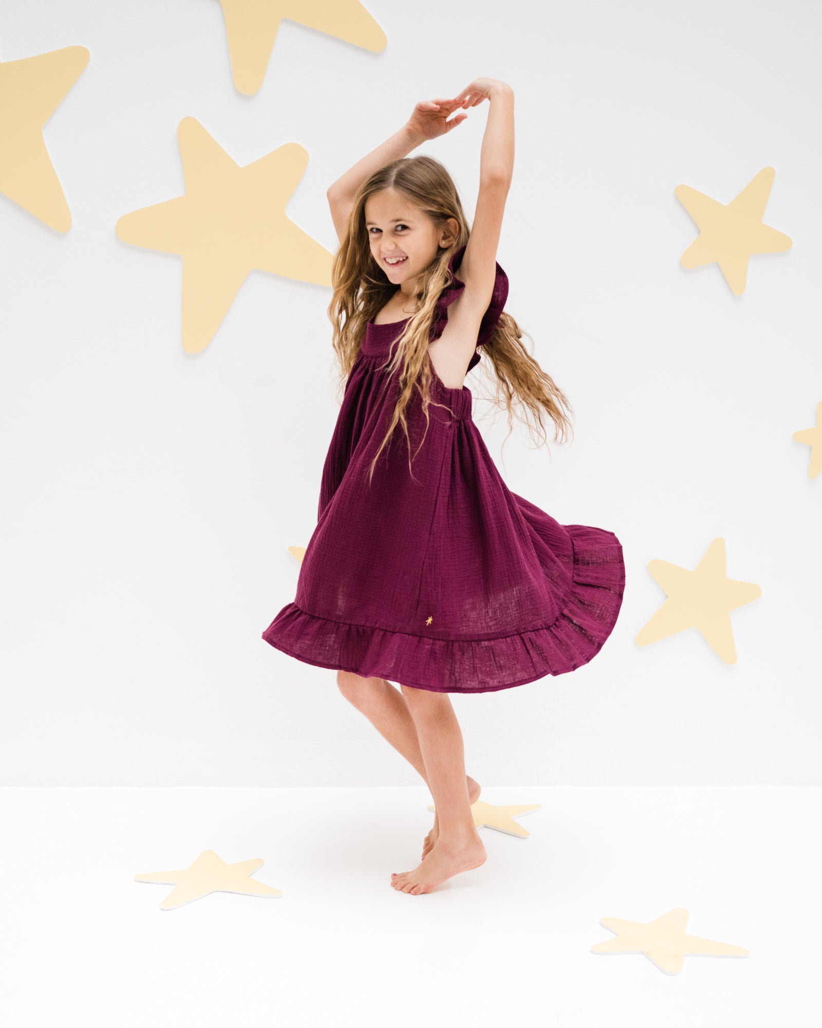 girl model showing the left side of the river dress in aubergine muslin cotton