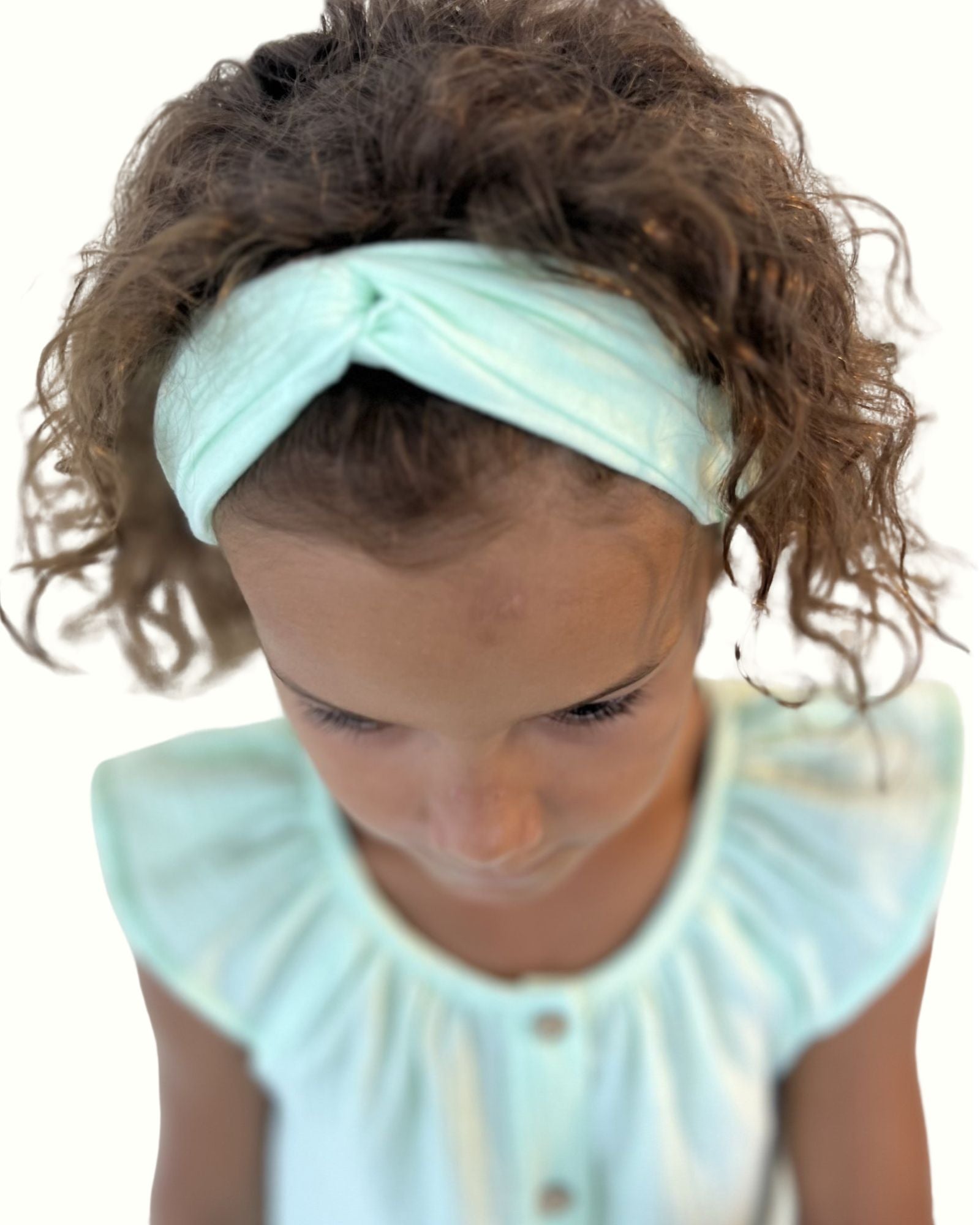 girl model showing the twisted headband by Les Vedettes in mint green muslin cotton