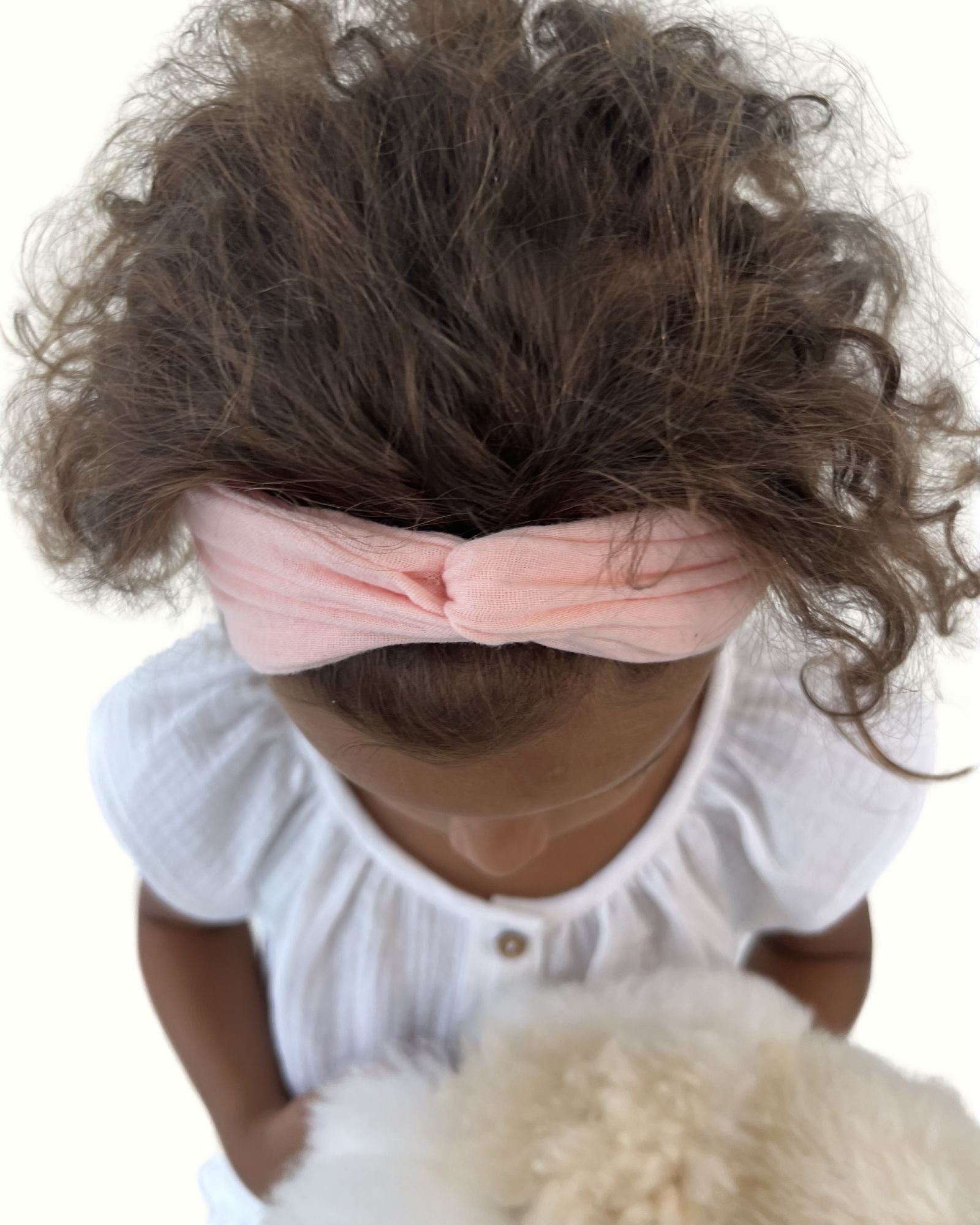 girl model showing the twisted headband by Les Vedettes in peach muslin cotton
