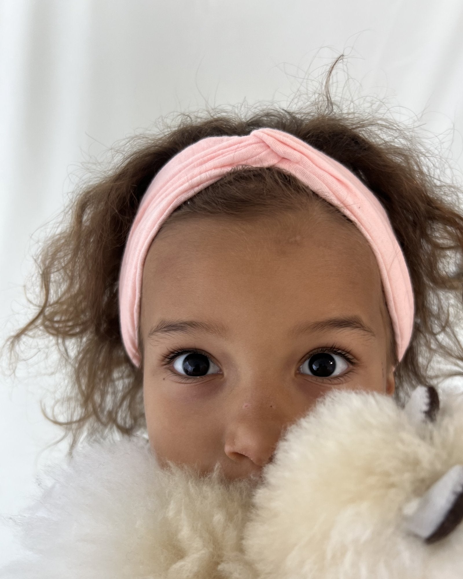 girl model showing the twisted headband by Les Vedettes in peach muslin cotton