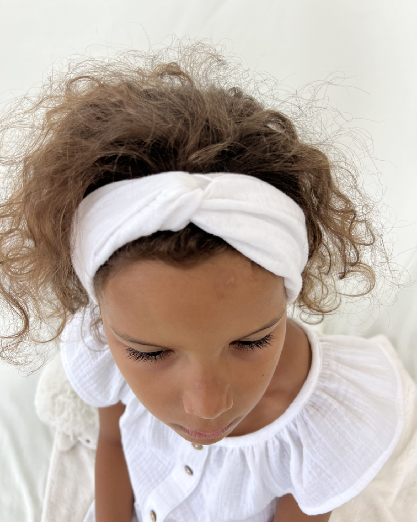 girl model showing the twisted headband by Les Vedettes in white muslin cotton
