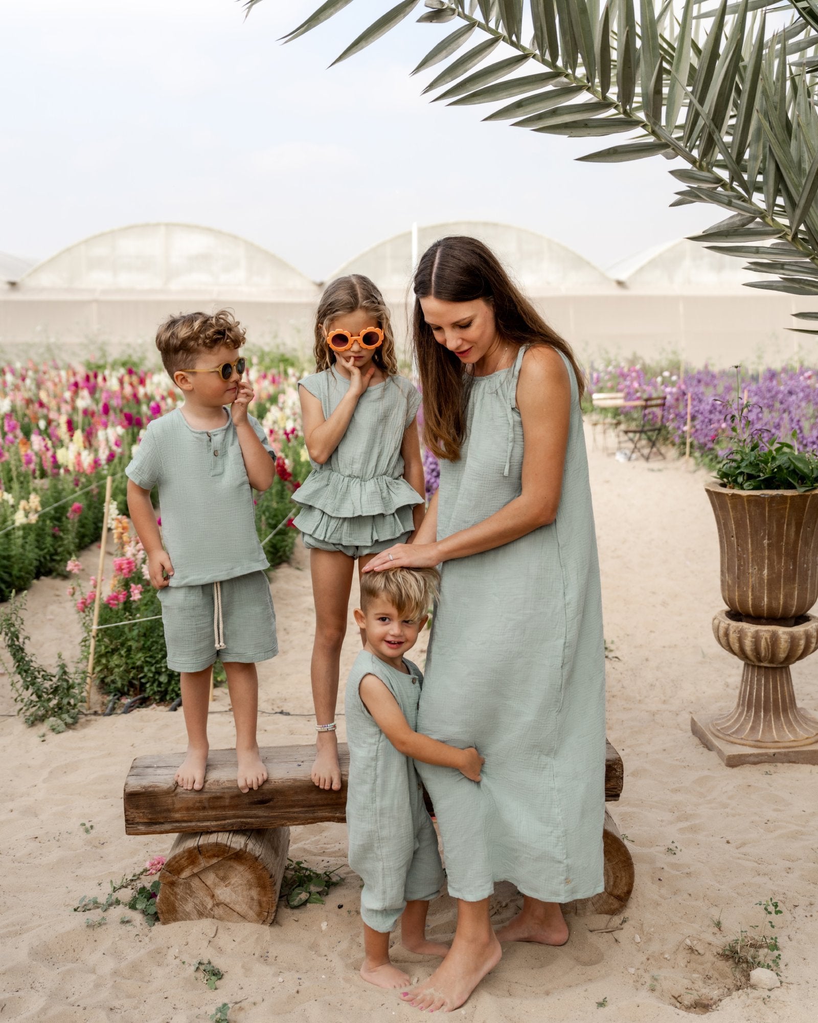 model wearing the sophia dress in sage in high quality muslin cotton by Les Vedettes and the kids are wearing matching clothes in sage