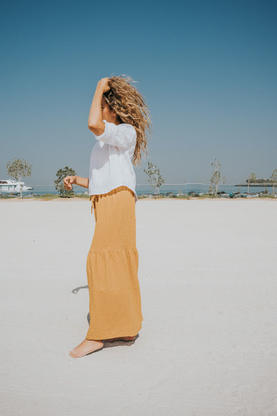 This maxi skirt from Les Vedettes is a long skirt that comes in a mustard colour. The skirt has an elastic and straps in the waist to easily adjust.