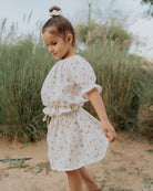 Girl model wearing the Alexa Top in Wildflower muslin cotton, with the matching Sienna Skirt and Scrunchie Long in Wildflower Muslin Cotton. .