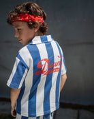 boy model wearing a blue and white striped shirt in cotton pique