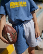 boy model wearing the ciss 1983 colour block jog shorts with the dream team t-shirt in organic cotton