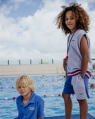 boy model wearing the color block jog shorts with the debardeur in grey