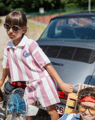 girl wearing the cut-off polo and track shorts, both in bold stripes pink in organic cotton pique 