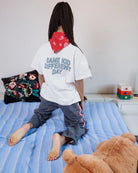 Girl wearing the white Same Kid Different Day kids T-shirt by Cos I Said So, back view