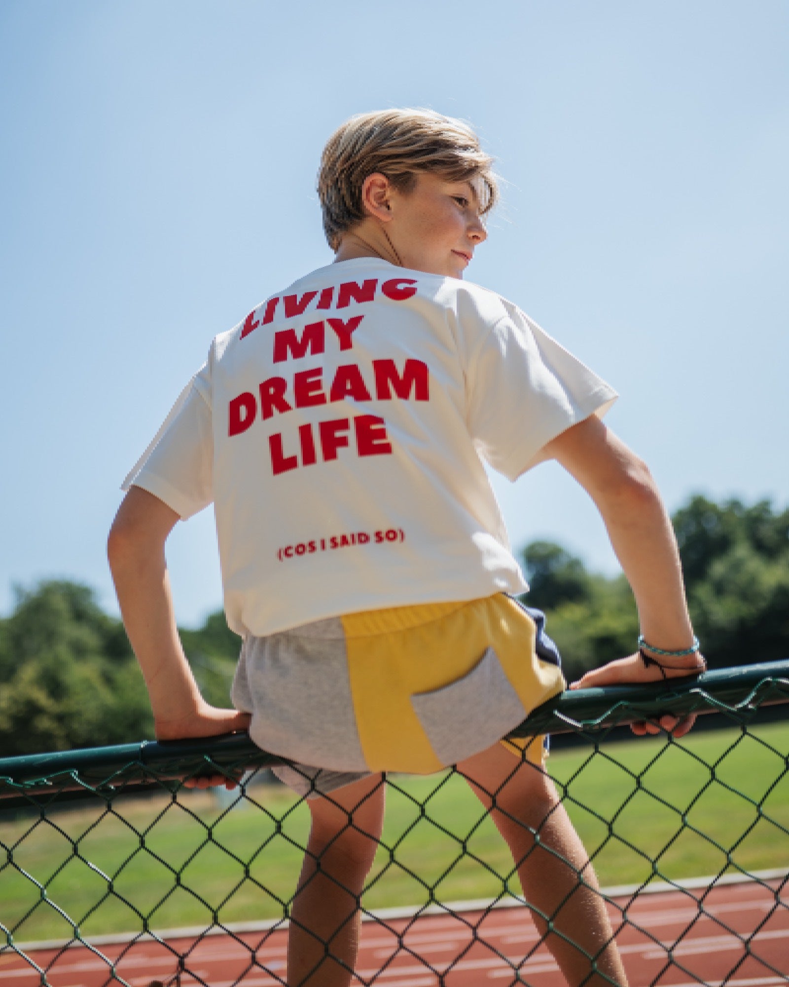 boy model showing the back side of the dream life t-shirt paired with the ciss 1983 colour block jog shorts