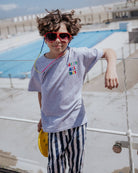boy model wearing the vacay all day t-shirt in the color grey in soft organic cotton