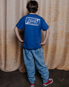 boy model wearing the voyage t-shirt in ultramarine blue in high quality organic cotton, showing the backside 