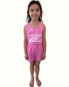 girl model wearing the comy cut off shorts by Cos I Said So in the vibrant color fuchsia with matching tank top voyage voyage in fuchsia high quality organic cotton