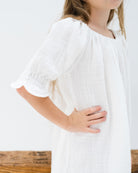 girl model showing the side of the alexa dress in white linen