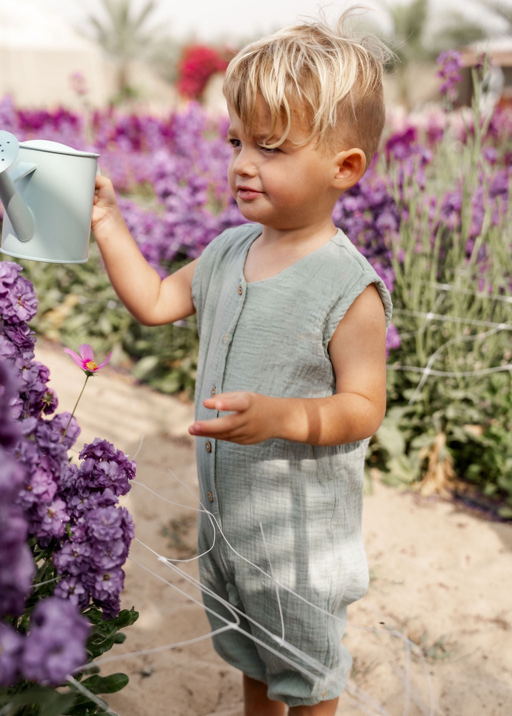 little boy wearing the Lois romper in sage green muslin cotton