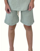 boy model wearing the boys shorts Julian by Les Vedettes in high quality muslin cotton in the color sage green 