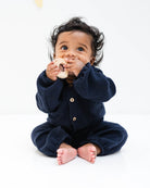 baby boy wearing the leo onesie with long sleeves in night blue muslin cotton