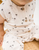 baby boy wearing the sleeveless lois onesie in palm print