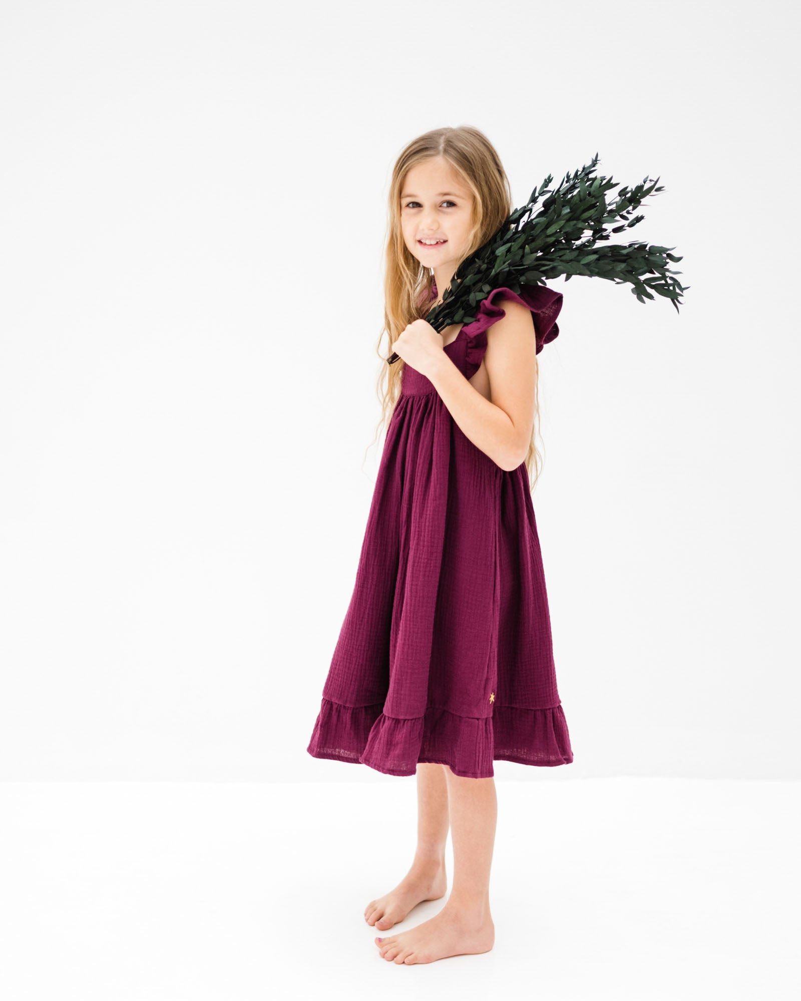 8-year-old girl wearing the River dress in aubergine